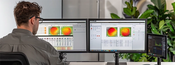 A man seated at a desk, analyzing data on two monitors, comparing insights from glean and BA methodologies.